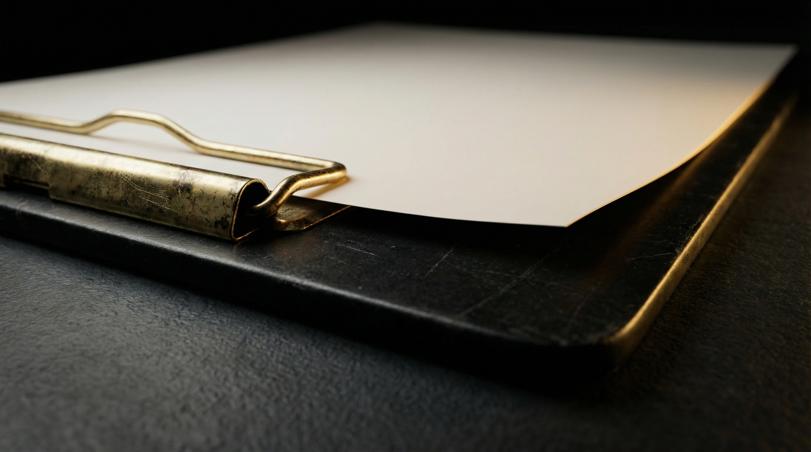 Matte black clipboard with gold metal clip and blank document — representing the LegitScript certification application requirement